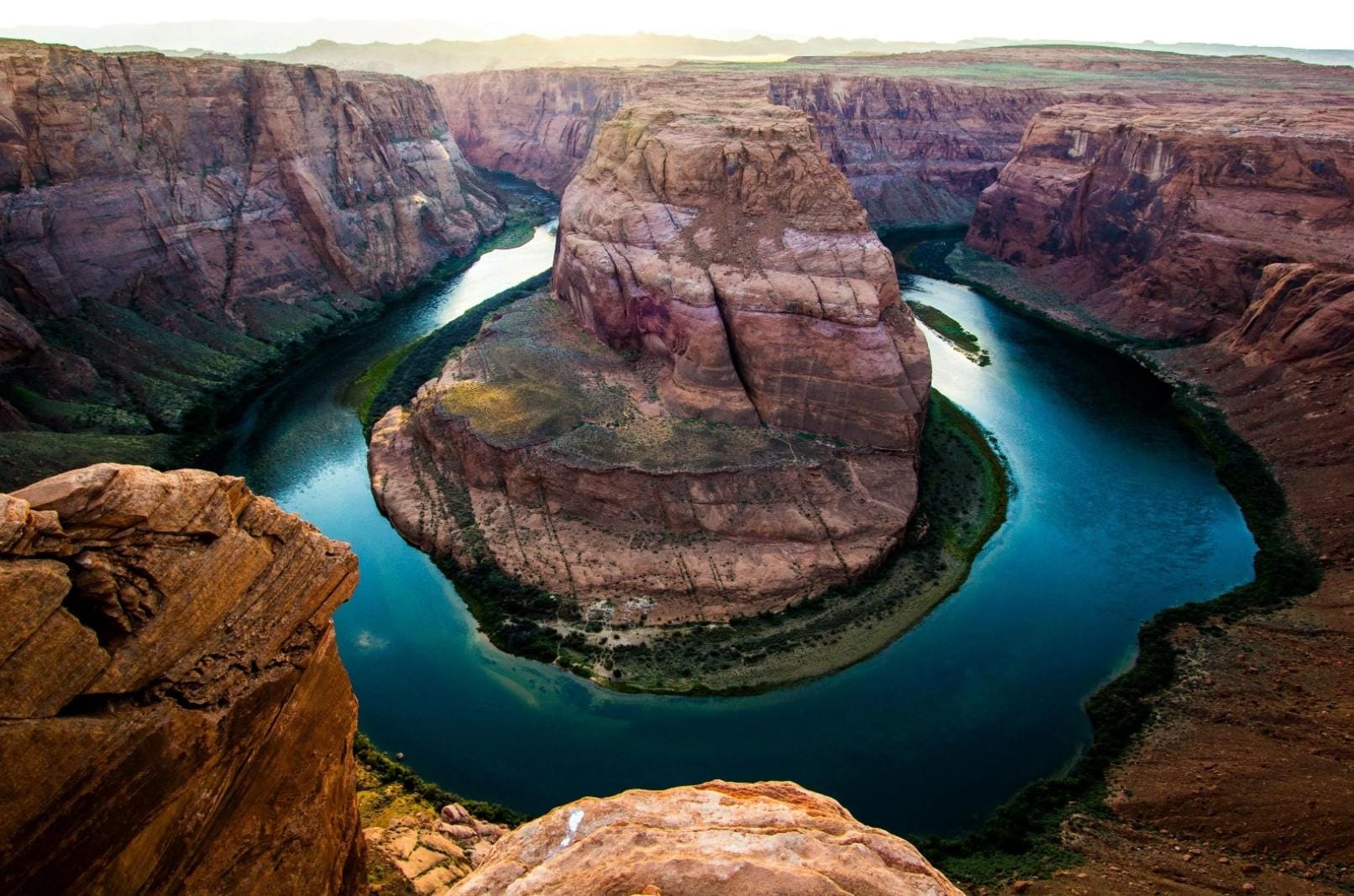 A low river winding through a deep canyon, surrounded by towering rock formations in the Grand Canyon.